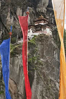 Images Dated 30th April 2010: Asia, Bhutan. Prayer flags hang near Taktshang or Tigers Nest, the most famous monastery in Bhutan