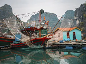 Asia, Vietnam, Quang Ninh, Ha Long Bay. Colorful fishing boat at its dock is reflected Asia, Vietnam, Quang Ninh, Ha Long Bay. Colorful fishing boat at its dock is reflected
