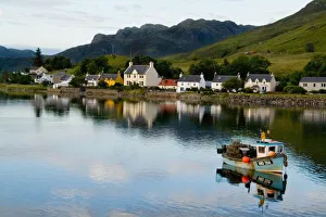 Beautiful photo of small village of Dornie with reflections and boat in Western Highlands Beautiful photo of small village of Dornie with reflections and boat in Western Highlands