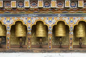 Images Dated 2nd October 2011: Bhutan. Spinning prayer wheels along a temple wall