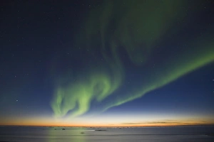 The Big Dipper hangs over curtains of green Aurora Borealis dancing over the iceberg The Big Dipper hangs over curtains of green Aurora Borealis dancing over the iceberg