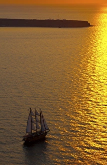Big masked sailboat sailing in sunset of beautiful Oia in Santorini Greece in Greek Big masked sailboat sailing in sunset of beautiful Oia in Santorini Greece in Greek
