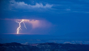 A bolt of lightning strikes the Utah desert as a rain storm moves across the landscape A bolt of lightning strikes the Utah desert as a rain storm moves across the landscape