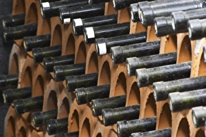 Bottles laying down piled high in terracotta earthenware tube containers. VitaI Vitaai Bottles laying down piled high in terracotta earthenware tube containers. VitaI Vitaai