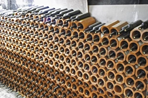 Bottles stored laying down piled high in terracotta earthenware tube containers Bottles stored laying down piled high in terracotta earthenware tube containers
