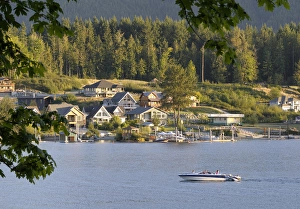 Canada, British Columbia, Cowichan Lake. Ski boat on Cowichan Lake in front of houses Canada, British Columbia, Cowichan Lake. Ski boat on Cowichan Lake in front of houses