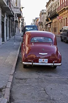 A classic old red Peugeot car parked on a street corner, probably from the 1950s A classic old red Peugeot car parked on a street corner, probably from the 1950s