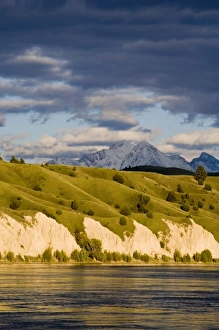 Clay Cliffs reflect into the Flathead River with Mission mountains in the background Clay Cliffs reflect into the Flathead River with Mission mountains in the background