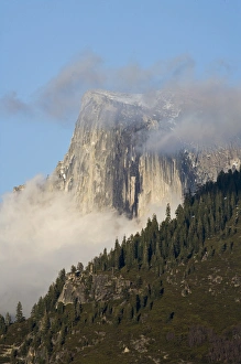 Clouds and fog gather around Half Dome - Yosemite National Park, California Clouds and fog gather around Half Dome - Yosemite National Park, California