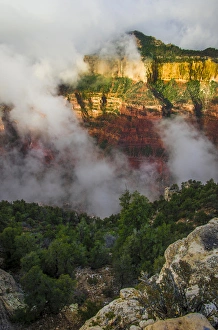 Clouds roll through the incredible rock formations of Bright Angel Point at the rugged Clouds roll through the incredible rock formations of Bright Angel Point at the rugged