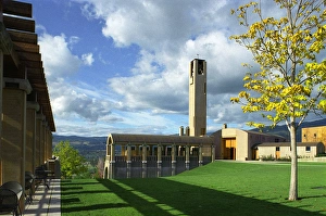 The concrete bell tower seems to touch the clouds in a blue sky over the architecturally The concrete bell tower seems to touch the clouds in a blue sky over the architecturally