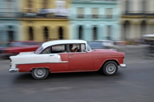 Cuba, Havana. A classic american car zooms along a city street Cuba, Havana. A classic american car zooms along a city street