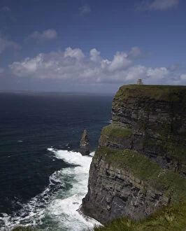 Distant scenic of the Cliffs of Moher and O Briens Tower under a blue sky