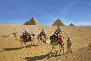 Great Pyramid Gallery: Egypt, Cairo, Giza, Tourists ride with a guide in front of the great pyramids