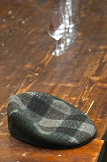 The emblematic cap of Alain Voge on a wooden table and some wine glasses. Alain Voge The emblematic cap of Alain Voge on a wooden table and some wine glasses. Alain Voge