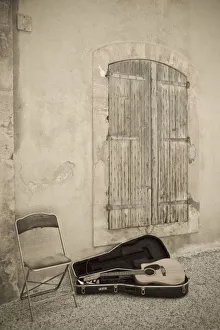 <b class=qtipBold><figcaption>Europe, France</figcaption></b><br>France village street scene. Still Life with guitar. Musician has temporarily exited the scene, with empty chair and guitar in its case, before a shuttered village window.<br><em>© Brenda Tharp / DanitaDelimont.com</em> Europe, France