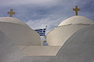 Europe, Greece, Cyclades, Sifnos, Vathi. Traditional Greek Orthodox church flying Greek flag Europe, Greece, Cyclades, Sifnos, Vathi. Traditional Greek Orthodox church flying Greek flag