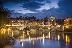Europe, Italy, Rome. Dome of Sistine Chapel with Tiber River and bridge lit at sunset