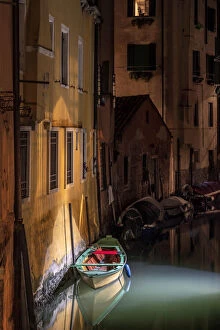 Jim Nilsen Gallery: Europe, Italy, Venice. Wooden boat and reflections on still canal at night