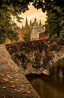 Fall leaf strewn bridge over a canal in Bruges, Belgium Fall leaf strewn bridge over a canal in Bruges, Belgium