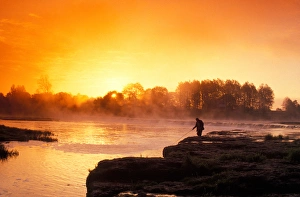 Fisherman at sunrise on Venta River waterfall at city of Kuldiga in Kurzeme region Fisherman at sunrise on Venta River waterfall at city of Kuldiga in Kurzeme region