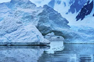Floating blue iceberg arch reflection, Paradise Bay, Skontorp Cove, Antarctica Floating blue iceberg arch reflection, Paradise Bay, Skontorp Cove, Antarctica