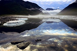 Fog forming in the Kongakut River valley as a storm passes at midnight in the Arctic Fog forming in the Kongakut River valley as a storm passes at midnight in the Arctic