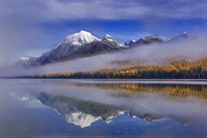 Fog lifts from Rainbow Peak and Bowman Lake in autumn in Glacier National Park, Montana Fog lifts from Rainbow Peak and Bowman Lake in autumn in Glacier National Park, Montana