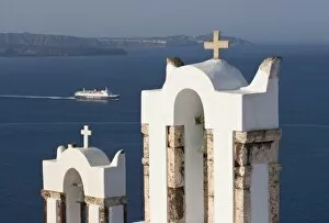 Images Dated 9th June 2005: Greece, Santorini, Thira, Oia. Two Greek Orthodox church bell towers and a Hellenic