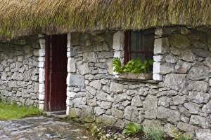 Ireland, Bunratty, County Clare. Traditional thatch and stone cottage in Bunratty Castle Ireland, Bunratty, County Clare. Traditional thatch and stone cottage in Bunratty Castle