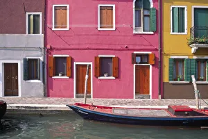 Italy, Burano. Colorful house exteriors and boat in canal Italy, Burano. Colorful house exteriors and boat in canal