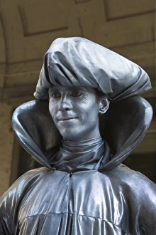 Italy, Florence. A mime in silver paint stands for a portrait Italy, Florence. A mime in silver paint stands for a portrait