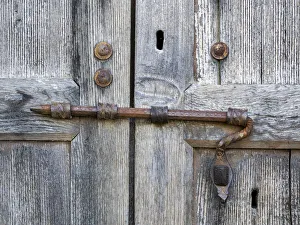 Italy, Tuscany. Unique metal door lock on an old wooden door Italy, Tuscany. Unique metal door lock on an old wooden door