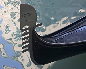 Italy, Venice. Close-up of ornate prow of gondola with water reflections Italy, Venice. Close-up of ornate prow of gondola with water reflections