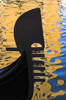 Italy, Venice. A silhouette of a gondola against colorful water reflections Italy, Venice. A silhouette of a gondola against colorful water reflections