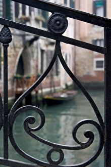 Italy, Venice. Stair railing metalwork design frames canal with gondola Italy, Venice. Stair railing metalwork design frames canal with gondola