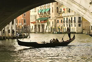 Italy; Venice. Tourist take snap shots from a gondola as they pass under the Rialto