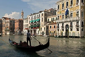 Italy, Venice. Tourists ride in a gondola on the Grand Canal of Venice