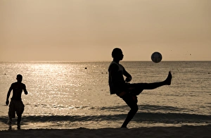 Jamaica, Negril, Silhouette of young men playing soccer along Caribbean Sea Jamaica, Negril, Silhouette of young men playing soccer along Caribbean Sea