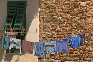 A line of clothes dries between buildings near an open air market in Figline, Tusacny, Italy A line of clothes dries between buildings near an open air market in Figline, Tusacny, Italy