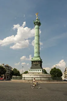 A lone cyclist pedals in front of the Colonne de Julliet at Place de la Bastille, Paris A lone cyclist pedals in front of the Colonne de Julliet at Place de la Bastille, Paris