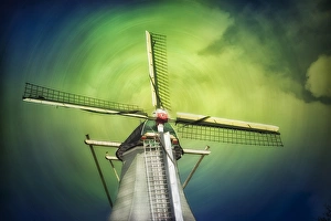 A lone windmill stands against the blue-green sky and clouds in swirl pattern A lone windmill stands against the blue-green sky and clouds in swirl pattern