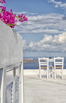 Two lonely romantic chairs on balcony with sky in Fira in Santorini Greece in Greek Two lonely romantic chairs on balcony with sky in Fira in Santorini Greece in Greek