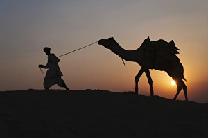 Man with camel on the desert at sunset, Jodphur, Rajasthan, India Man with camel on the desert at sunset, Jodphur, Rajasthan, India