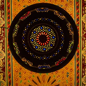Morocco. A graphic silhouetted detail of a metal Moroccan lamp in a ceiling of a Morocco. A graphic silhouetted detail of a metal Moroccan lamp in a ceiling of a
