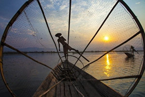 Myanmar, Inle Lake. Fishermen rowing at sunset Myanmar, Inle Lake. Fishermen rowing at sunset