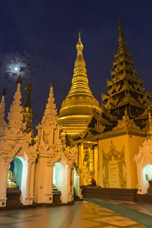 Myanmar, Yangon. Golden stupa and temples of Shwedagon Pagoda at night with moon Myanmar, Yangon. Golden stupa and temples of Shwedagon Pagoda at night with moon