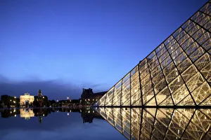 The night view of the glass Pyramid of Musee du Louvre with Arc de Triomphe du Carrousel The night view of the glass Pyramid of Musee du Louvre with Arc de Triomphe du Carrousel