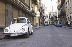 An old white Volksvagen Beetle probably from the 1960s parked on the street in the An old white Volksvagen Beetle probably from the 1960s parked on the street in the
