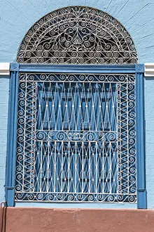 Ornate wrought iron covering on blue wooden window shutters, Trinidad, Cuba Ornate wrought iron covering on blue wooden window shutters, Trinidad, Cuba
